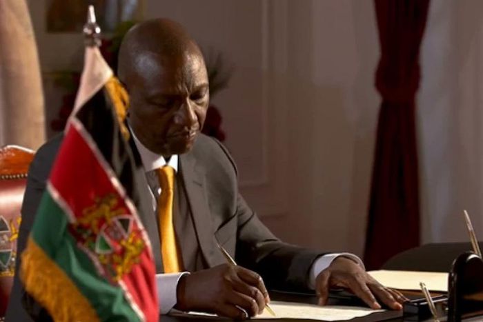 President William Ruto signs a document at State House