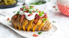 Hasselback sweet potatoes served with seasoned yogurt