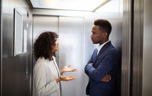 Black couple inside an elevator [Adobe Stock]