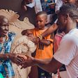 Rickman Manrick shakes hands with an elderly woman while in Bakuli, Kampala. Image credit: Bryan Morel Publications.