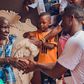 Rickman Manrick shakes hands with an elderly woman while in Bakuli, Kampala. Image credit: Bryan Morel Publications.