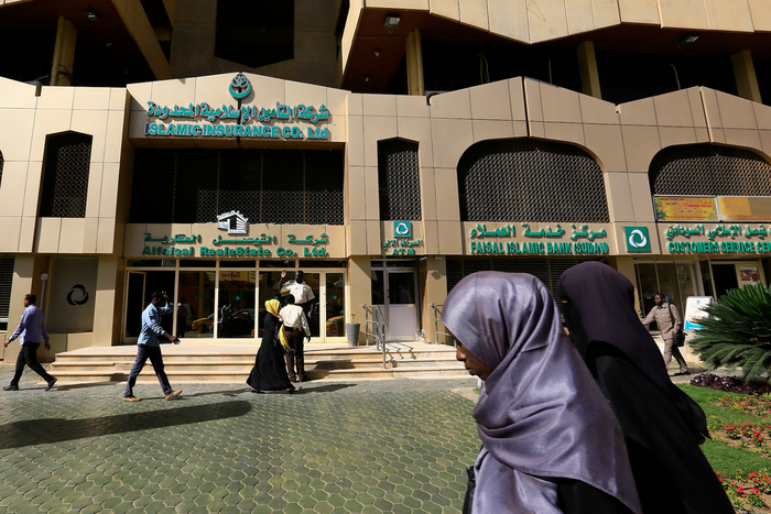 People walk past the Faisal Islamic Bank in Khartoum, Sudan January 12, 2016.