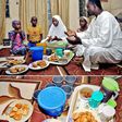 A father and his family sit around a meal for Iftar during Ramathan