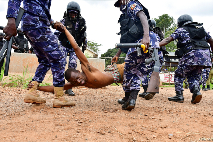 Police detain a protestor in Luuka