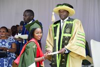 A graduand receives a document from Mulenga during the graduation event