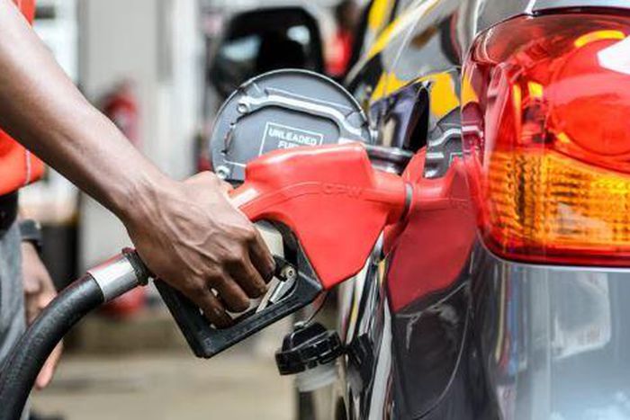 Attendant putting fuel in a car