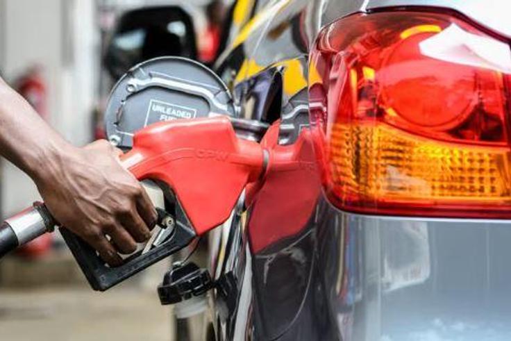 Attendant putting fuel in a car