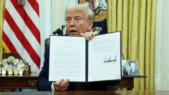 U.S President Donald Trump holding an executive order signed on his first day in office