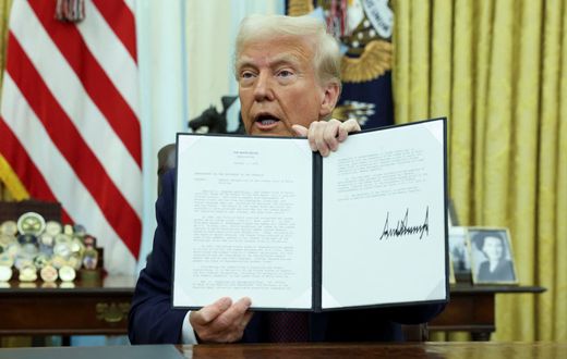 U.S President Donald Trump holding an executive order signed on his first day in office
