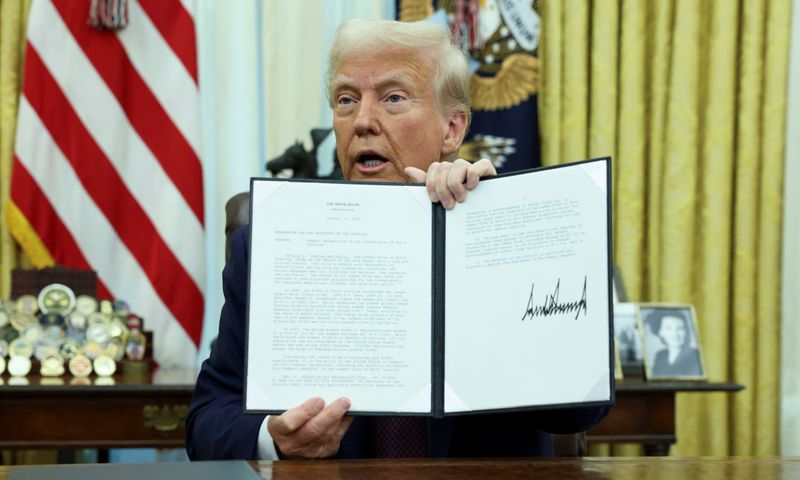 U.S President Donald Trump holding an executive order signed on his first day in office
