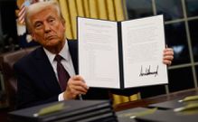 U.S President Donald Trump holding an executive order signed on his first day in office