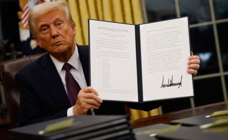 U.S President Donald Trump holding an executive order signed on his first day in office