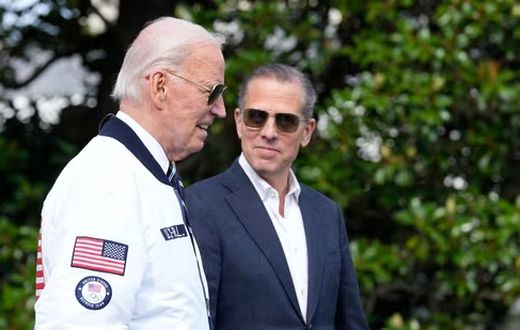President Joe Biden, wearing a Team USA jacket and walking with his son Hunter Biden, heads toward Marine One on the South Lawn of the White House in Washington, July 26, 2024. (AP)