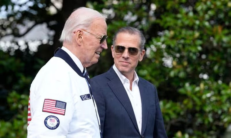 President Joe Biden, wearing a Team USA jacket and walking with his son Hunter Biden, heads toward Marine One on the South Lawn of the White House in Washington, July 26, 2024. (AP)