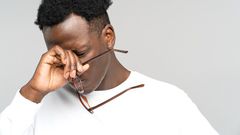 A man holding his glasses