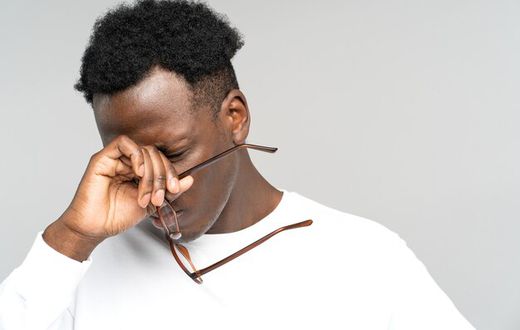 A man holding his glasses