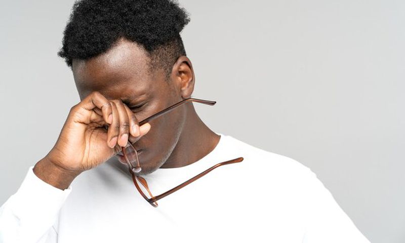 A man holding his glasses