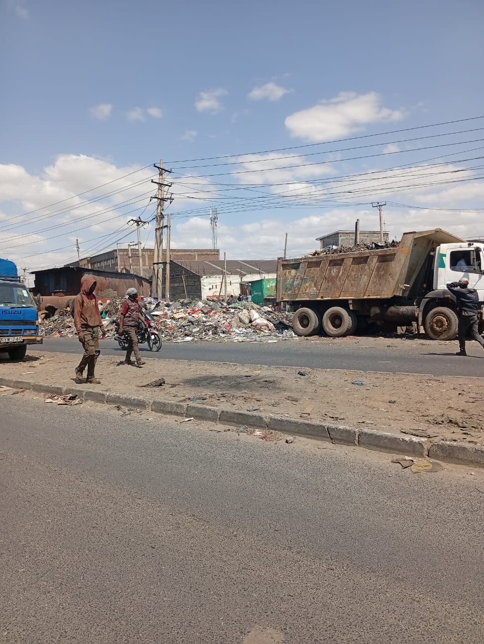 Vehicles driving past a pile of garbage along Enterprise Road, Nairobi