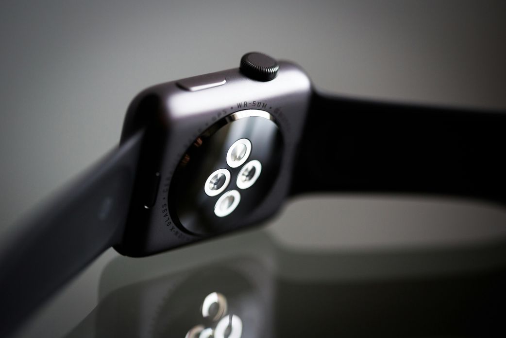The underside of a smartwatch with sensors showing