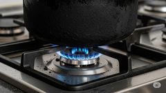 A sufuria with soot on a gas burner
