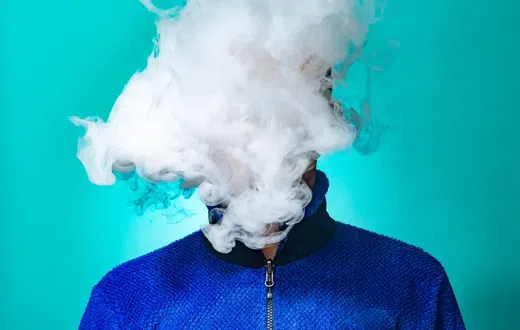 A person with a cloud of smoke on their face