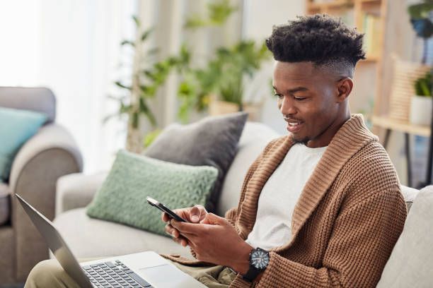 A person texting while using their laptop