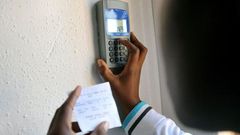 Kenyan keys in token recharge into a token meter