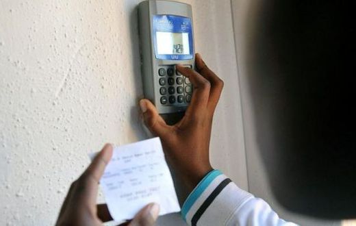 Kenyan keys in token recharge into a token meter