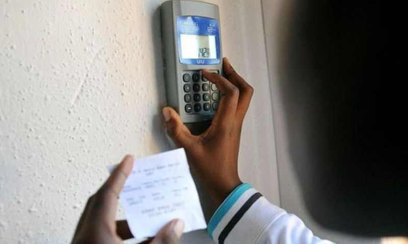 Kenyan keys in token recharge into a token meter