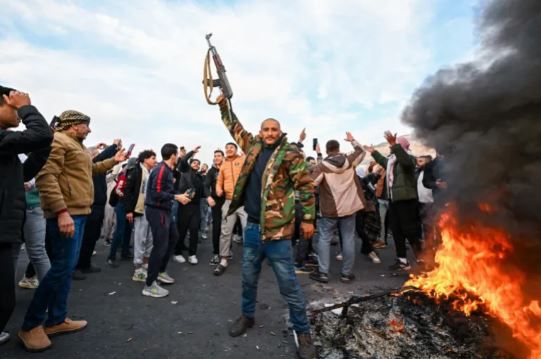 People celebrate with anti-government fighters at Umayyad Square in Damascus on December 8, 2024