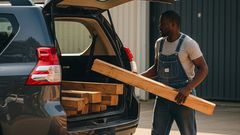 An AI-generated image of a man loading timber to a prado