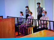 Aung San Suu Kyi, pictured far left, in court
