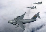 A C-17 plane being escorted by F-15 aircraft. U.S. Air Force photo by Tech. Sgt. Shane A. Cuomo