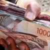 A person holding a wad of cash