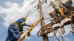 A Kenya Power staffer climbing a pole