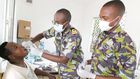 A Kenya Defence Forces specialist officer (middle) offers dental services to a civilian