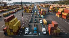 Parked trucks and cargo containers in a port [Image Creidt: Kelly]