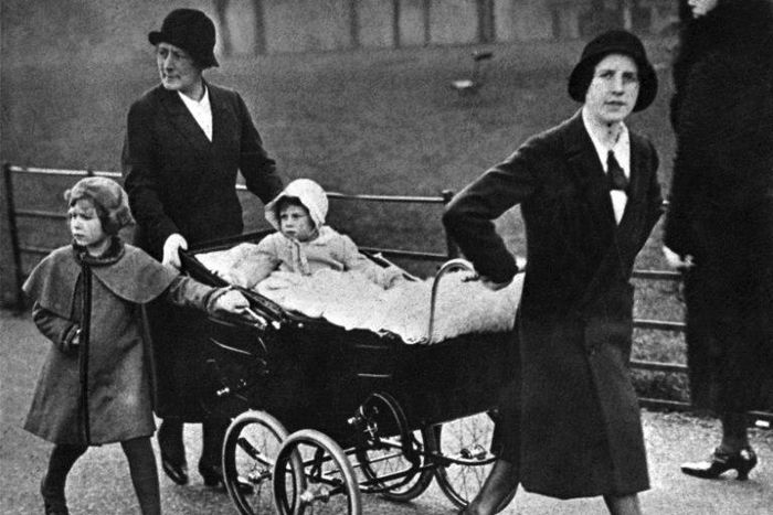 Britain's Queen Elizabeth II (left) as a child with her younger sister Princess Margaret and nannies