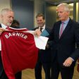 British Labour Party leader Jeremy Corbyn (L) presents EU Brexit negotiator Michel Barnier with an Arsenal football jersey at talks in Brussels