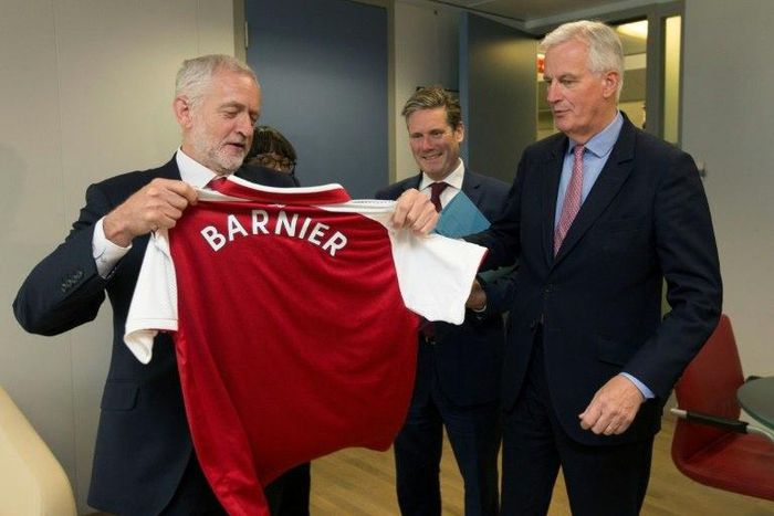 British Labour Party leader Jeremy Corbyn (L) presents EU Brexit negotiator Michel Barnier with an Arsenal football jersey at talks in Brussels