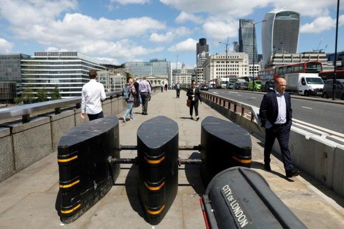 Pedestrians walk pass newly installed barriers on the pavement on London Bridge following the June 3 terror attack in London which killed seven people and injured 48.