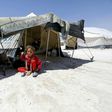 A Syrian girl, who fled the countryside surrounding the Islamic State group's Syrian stronghold of Raqa, sits in the shade of a tent at a temporary camp in the village of Ain Issa on July 11, 2017
