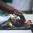 A woman looks after her child in the encephalitis ward of the the Baba Raghav Das Medical College where dozens of children have died in the past week