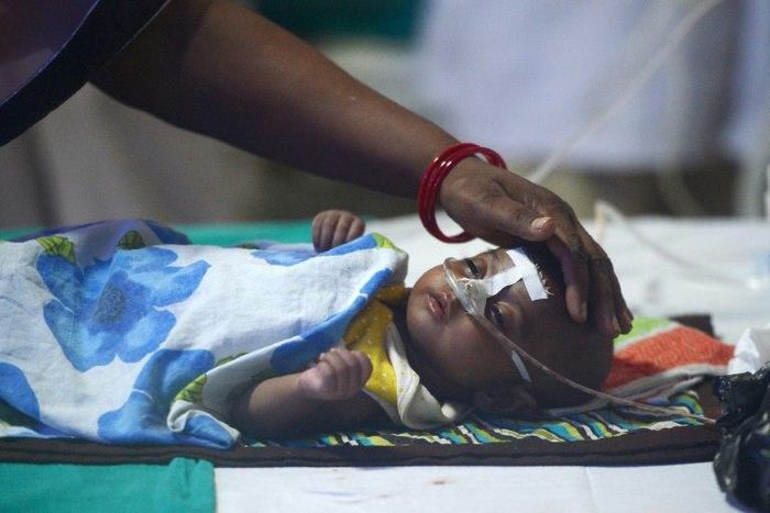 A woman looks after her child in the encephalitis ward of the the Baba Raghav Das Medical College where dozens of children have died in the past week