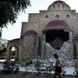 A woman walks past a damaged church on the Greek island of Kos following a 6.7 magnitude earthquake which struck the region on July 21, 2017