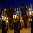Migrants try to jump over a fence into a ferry terminal in Patras, southwestern Greece, on June 20, 2017