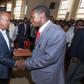President Uhuru Kenyatta receives a Bible on Fathers' Day, from Kimende boda boda rider Destiny Gitau, at St Peter and Paul Catholic Church in Kiambu town, June 18, 2017.