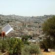 An Israeli settler stands on Palestinian land overlooking the Ibrahimi Mosque and the old city of the West Bank town of Hebron