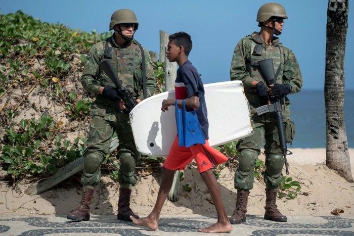 Brazilian soldiers stand guard on Ipanema beach in Rio de Janeiro on July, 29, 2017, following the government decision to deploy some 8,500 troops in the city to fight organized crime and a spike in street violence