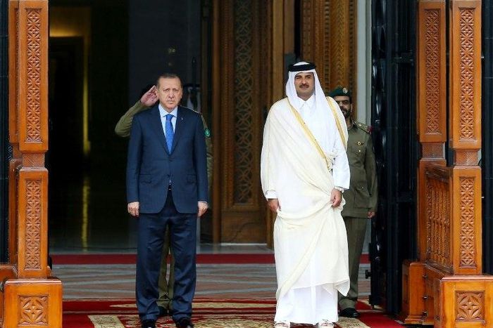 This handout photo taken and released by Turkey's Presidential Press Service on February 15, 2017 shows the Emir of Qatar Tamim bin Hamad Al Thani (R) and Turkish President Recep Tayyip Erdogan (L) attending a welcome ceremony in Doha